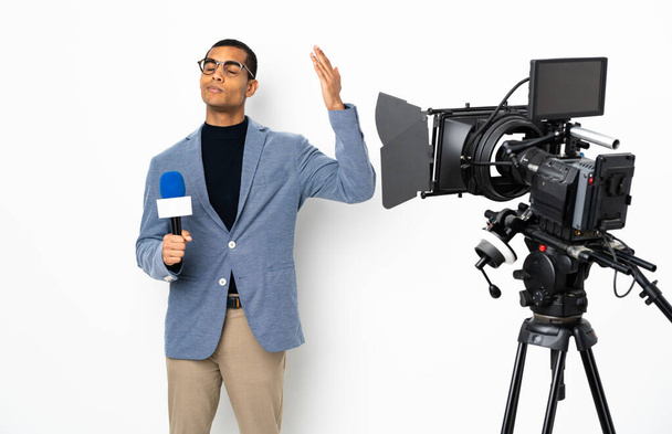 Репортер афроамериканец держит микрофон и сообщает новости на изолированном белом фоне с усталым и больным выражением лица
 - Фото, изображение
