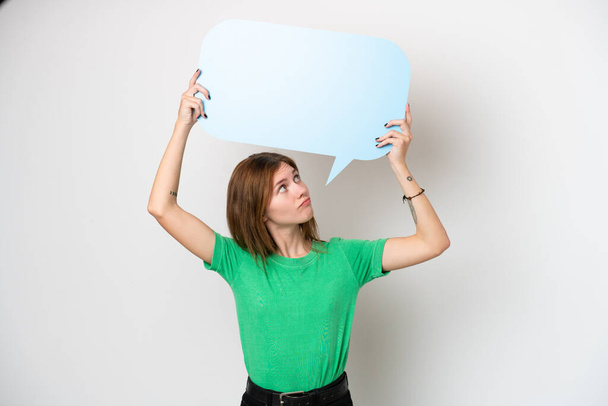 Young English woman isolated on white background holding an empty speech bubble and with sad expression - Foto, immagini
