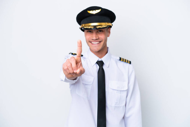 Flugzeug kaukasischen Piloten isoliert auf weißem Hintergrund zeigt und hebt einen Finger - Foto, Bild