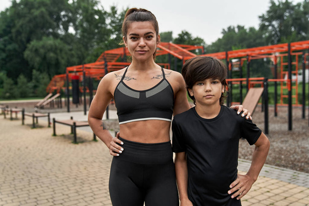 Confident sports mother and son looking at camera - Фото, изображение