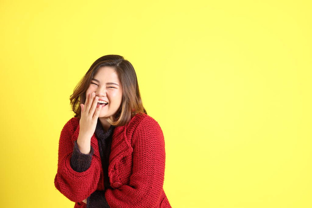 The chubby Asian woman standing on the yellow background with the casual clothes. - Photo, Image
