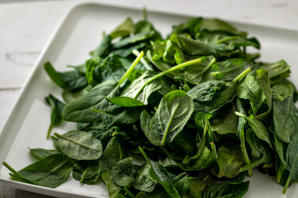 Frozen spinach, on a light background, green leaves with frost - Zdjęcie, obraz
