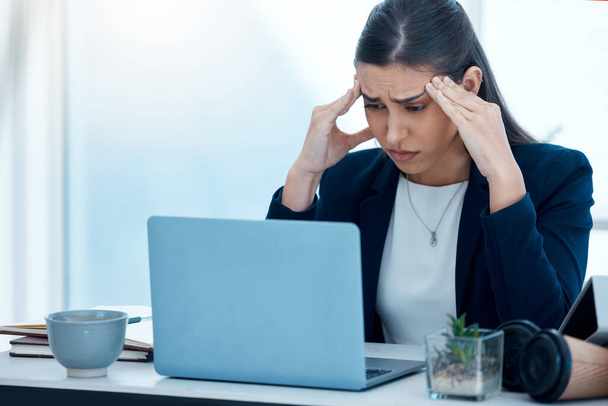 No sé cuál es el problema. Fotografía de una joven mujer de negocios que parece estresada mientras trabaja en una computadora portátil en una oficina. - Foto, imagen