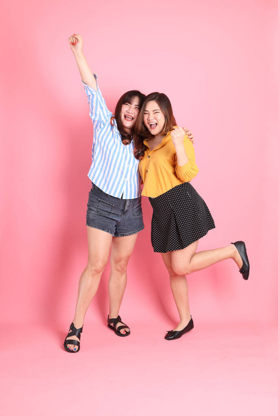 The Asian happy sibling standing on the pink background. - Foto, imagen