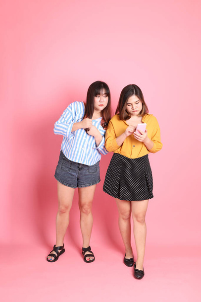 The Asian happy sibling standing on the pink background. - Fotó, kép