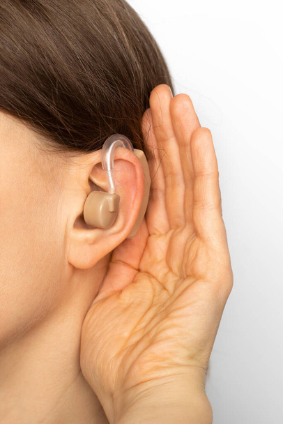 Gehoorapparaat op het oor van een vrouw, close-up. - Foto, afbeelding