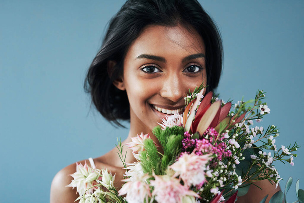 Flowers are a surefire way to grab a womans attention. Cropped shot of a beautiful young woman posing with a bouquet of flowers. - Foto, immagini