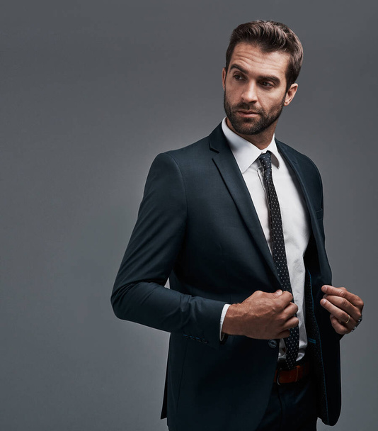 He knows how to pull off an outstanding first impression. Studio shot of a handsome young businessman posing against a grey background. - Foto, Bild