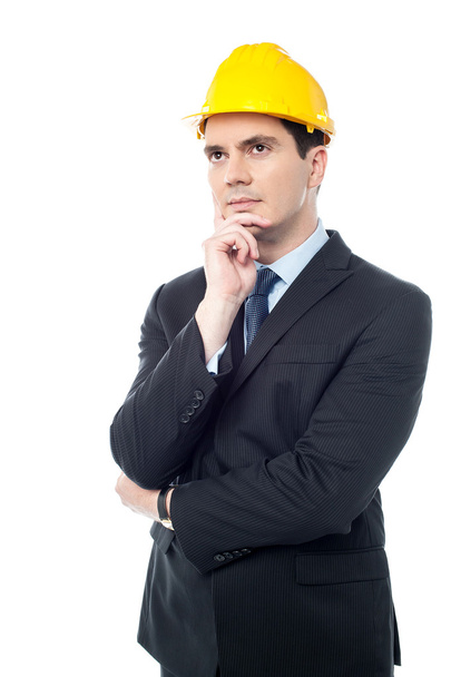Thoughtful architect wearing a hard hat - Foto, afbeelding