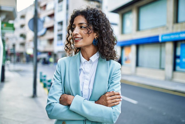 Young hispanic business woman wearing professional look smiling confident at the city - Photo, Image
