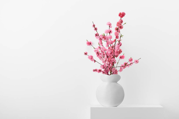Flowering peach branches in a white vase - Photo, image