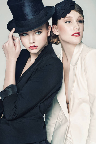 Fancy dressing. Zwei glamouröse Frauen posieren gegen Weiß. - Foto, Bild