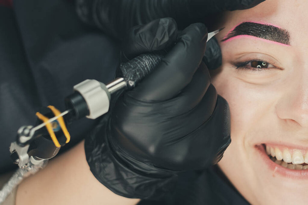 The master of permanent make up performs eyebrow microblading in beauty salon - Fotoğraf, Görsel