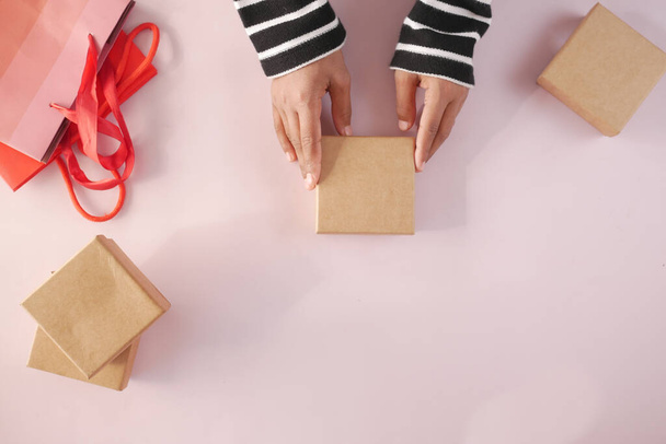top view of hand hold homemade gift box on color background  - 写真・画像