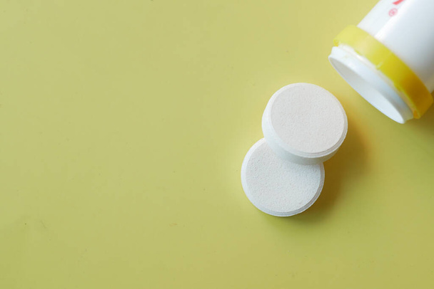 Effervescent soluble tablet pills on yellow  - Foto, Bild