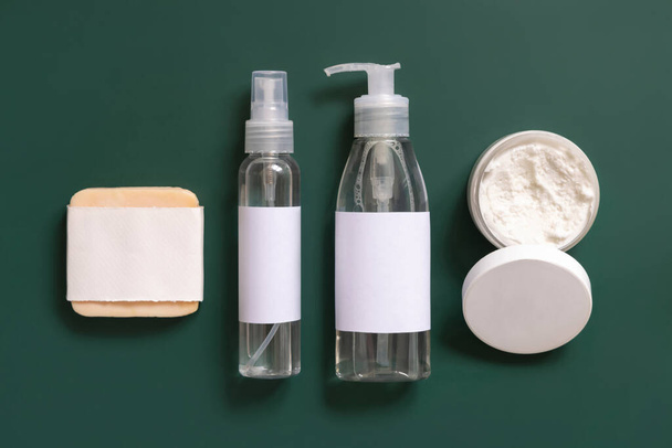 Homemade Cosmetics in plastic tubes and bottles on dark green top view. Brand packaging mockup. Organic natural cosmetics for skin and hair care - 写真・画像