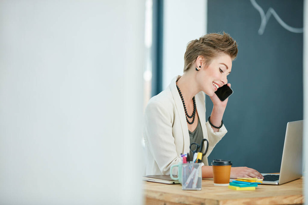 Technologia ta odpowiada jej potrzebom biznesowym. Przycięte zdjęcie młodej bizneswoman rozmawiającej przez komórkę w biurze. - Zdjęcie, obraz