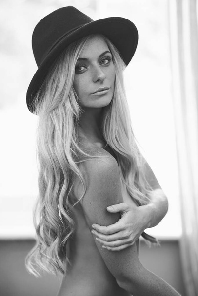 Real life Repunzel. Shot of a gorgeous young topless woman posing in a hat at home. - Valokuva, kuva