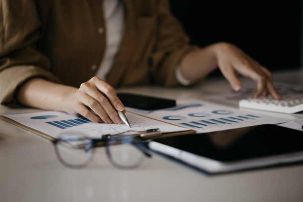 A business finance woman is reviewing a company's financial documents prepared by the Finance Department for a meeting with business partners. Concept of validating the accuracy of financial numbers. - Photo, image