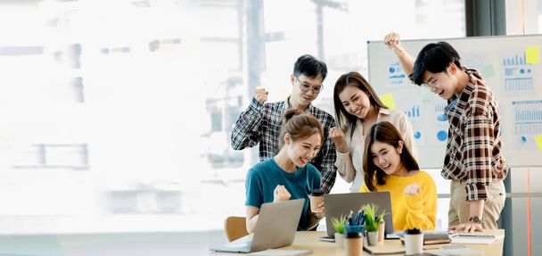 A group of startup company employees are in the conference room, raising their hands to show their appreciation after looking at the company's sales and profitable results. Startup company concept. - Foto, Imagen