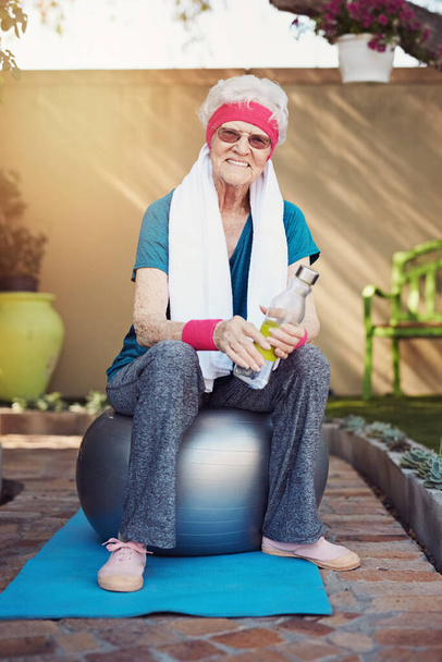 Mantener un estilo de vida activo. Fotografía de una mujer mayor ejercitándose en casa. - Foto, Imagen