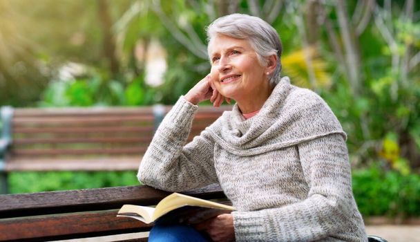 Huzur içinde kitap okumak gibisi yoktur. Parkta tek başına kitap okuyan neşeli, yaşlı bir kadının görüntüsü.. - Fotoğraf, Görsel