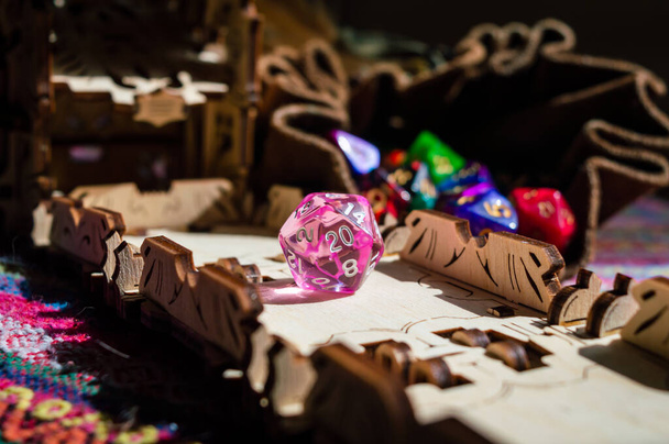Image of a pink 20-sided role-playing die just rolled out of a dice tower - Foto, Bild