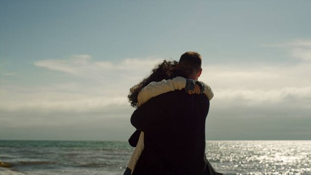 Rakastava pari nauttimassa meren rannalla. Onnelliset ihmiset halailevat yhdessä aurinkoisena päivänä.. - Valokuva, kuva