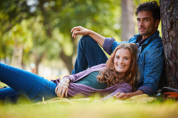 They are so cute together. Shot of a smiling young couple enjoying the day together at the park. - Foto, Imagen