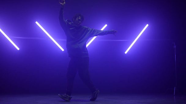Tänzerin im Hip-Hop-Nachtclub. Silhouette B-boy macht agile Bewegungen. - Foto, Bild