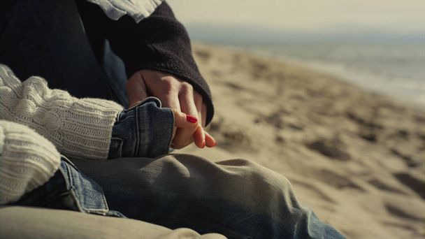 Lovers holding hands together on sand beach. Couple relaxing on sea coast shore. - Photo, Image