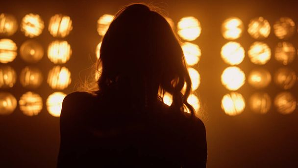 Silhouet professionele vrouw vocalist optreden in nachtclub lichten close-up. - Foto, afbeelding