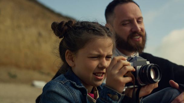 Petit enfant tenant appareil photo faisant des photos de mer plage paysage voyage en famille. - Photo, image