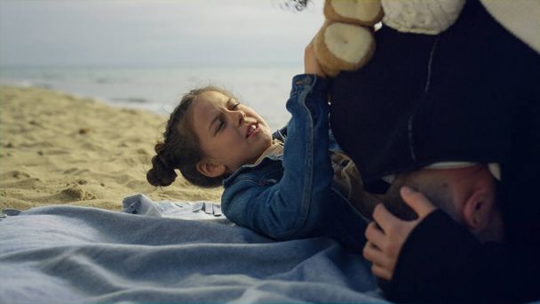 Petit enfant jouer parents sur la plage de la mer. Passer du temps en famille ensemble au bord de la mer. - Photo, image