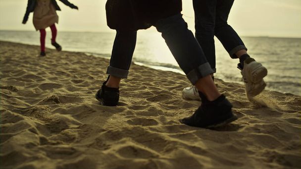 日没の海の自然で人々の足のビーチステップ。砂浜を歩く家族. - 写真・画像