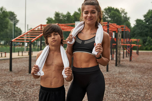 Caucasian mother and son together on sports ground - Фото, изображение