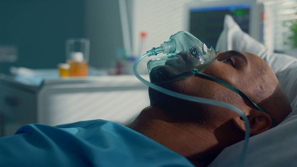 Ο γιατρός να λάβει σωλήνες covid19 για κλινική δοκιμή. Ασθενής ξαπλωμένος σε μάσκα οξυγόνου κοντά - Φωτογραφία, εικόνα