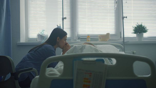 Мати турбується про хвору дитину після терапії в клініці. Серйозно хвора дитина лежить в ліжку
.  - Фото, зображення