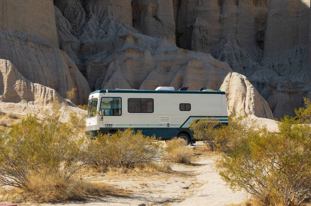 Red Rock Canyon State Park, California, USA - February 6, 2021: image of a Trek Pathmaker RV shown against an eroded mountain side. - Foto, Bild