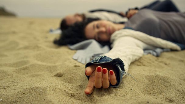 恋人たちは海でビーチを楽しむ。砂の海岸でリラックスした冷たいカップル. - 写真・画像