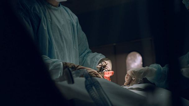 Cirujano realizando una dura operación sacando un tampón sangriento en la sala de emergencia. - Foto, imagen