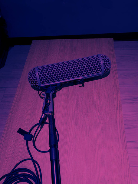 Boom Mikrofon oder Umgebungsmikrofon zur Tonaufnahme in der Videoproduktion. Boom Mikrofone legen sich auf den Holztisch, nachdem sie in einem Online-Film verwendet wurden. Pro-Tools zur Aufnahme von Filmton in einem großen Studio - Foto, Bild