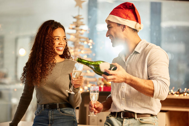 O que é uma celebração sem o champanhe? Tiro de dois jovens empresários comemorando o Natal no trabalho. - Foto, Imagem
