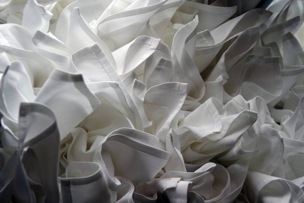 Tray of clean white folded cloth napkins in a restaurant - Foto, Imagen