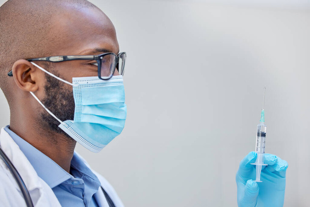 Sind Sie bereit, sich impfen zu lassen? Aufnahme eines jungen Arztes, der bei der Arbeit eine mit Flüssigkeit gefüllte Spritze hält. - Foto, Bild