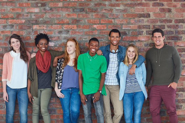 Todos sonríen en el campus. Retrato de un grupo de estudiantes universitarios de pie en su edificio universitario. - Foto, Imagen