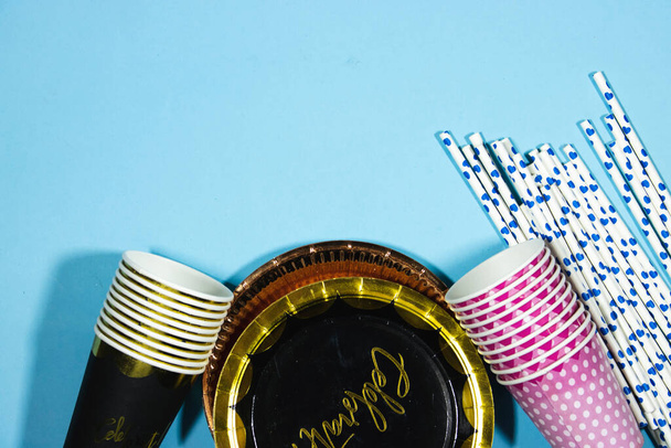 narozeninová party koncept jednorázové poháry a slámy a lepenkový talíř na modrém pozadí - Fotografie, Obrázek