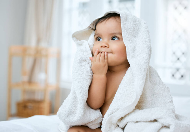 I taste so fresh. Shot of an adorable baby covered in a towel after bath time. - Foto, imagen