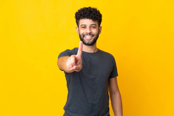 Young Moroccan man isolated on yellow background showing and lifting a finger - Фото, зображення