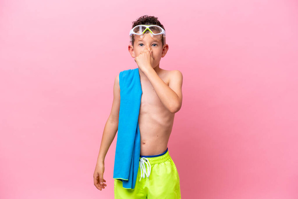 Piccolo ragazzo caucasico che indossa una maschera subacquea isolata su sfondo rosa - Foto, immagini